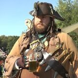 Ein als Pirat verkleideter Mann hält einen Krug Bier in der Hand.