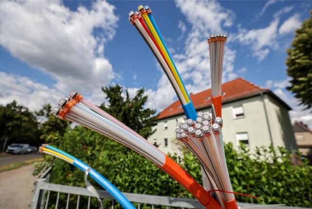 Links ist eine Stadt aus der Vogelperspektive, rechts sind Glasfaserkabel auf einer Baustelle.
