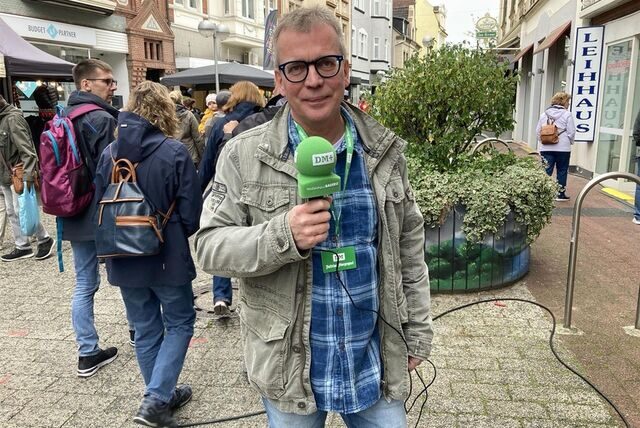 DMP-Redakteur Uwe Wallkötter steht auf der Hohe Straße in Datteln und hält ein Mikrofon in der Hand.