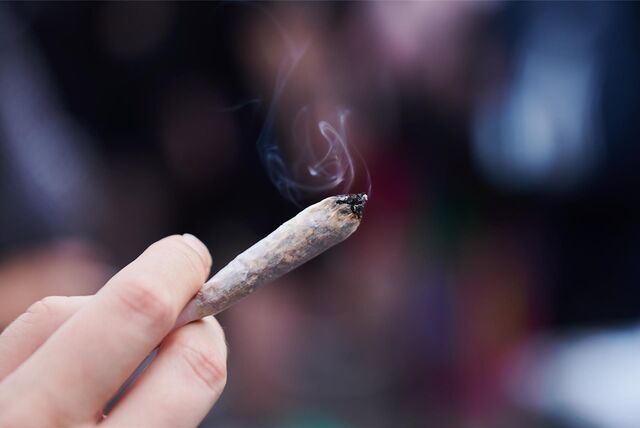 Eine Frau hält einen Joint in der Hand