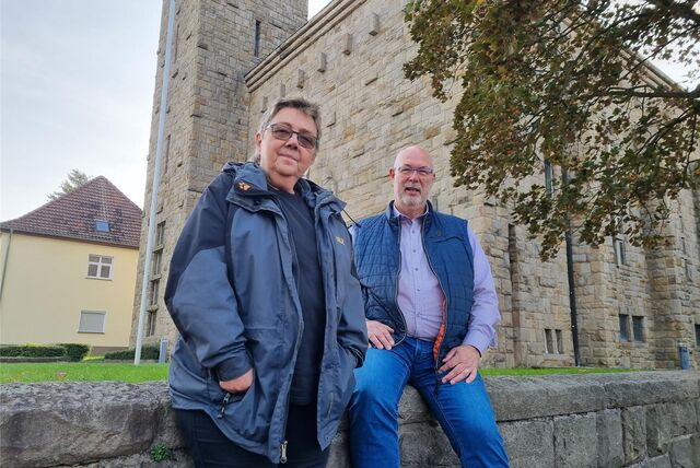 Ein Mann und eine Frau stehen vor einer Kirche.