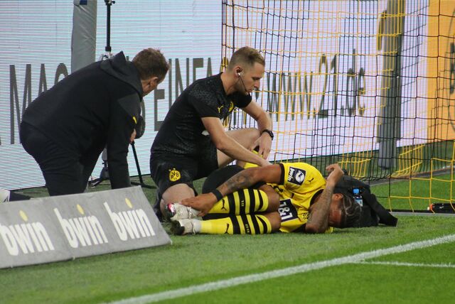Justin Butler liegt neben dem Spielfeldrand auf dem Rasen.