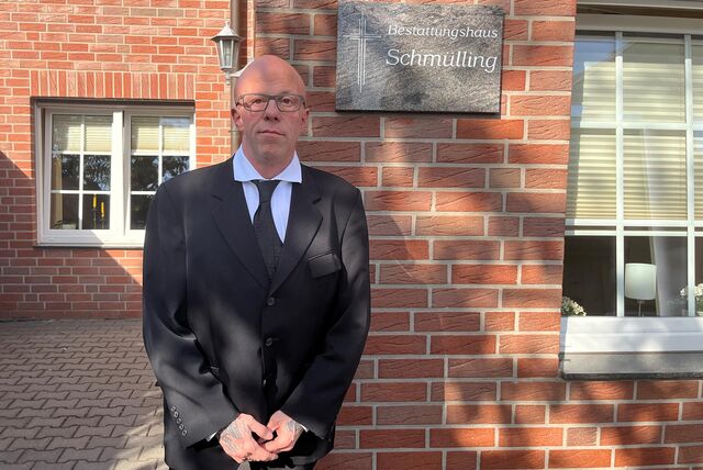 Carsten Spiekermann steht im schwarzen Anzug vor einer Hauswand.