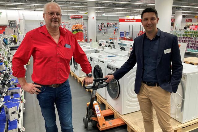 Michael Herbstmann (Media Markt) und Gerrit Beckmann (Palais Vest) stehen vor einem Waschmaschinen-Sortiment im Palais Vest Recklinghausen.