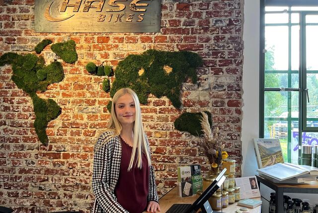 Eine junge Frau steht am Empfang bei der Verkaufsstelle von Hase Bikes.