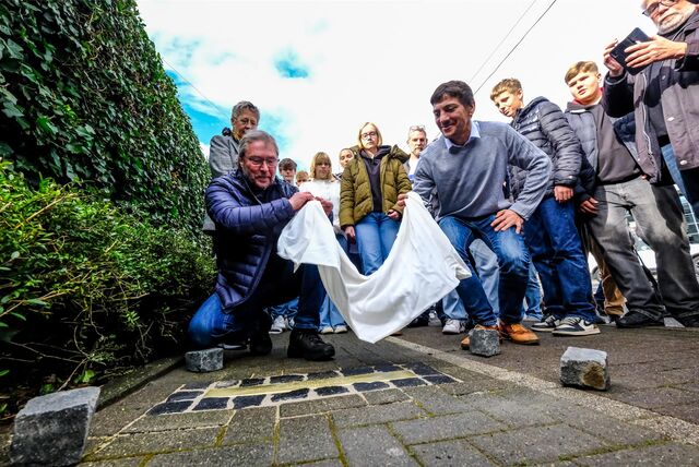 Jürgen Pohl vom Verein für Orts- und Heimatkunde (l.) und Bunker-Bewohner Yassin enthüllten unter den Augen von Maristen-Realschülern die Stolperschwelle vor dem Hochbunker an der Hohenzollernstraße.