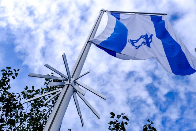 Die israelische Flagge hängt an einem Mast, darunter ist eine sternförmige Metallkonstruktion zu sehen.