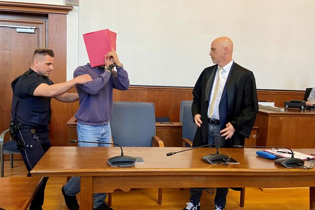 Jalal J. hält sich vor Gericht eine Mappe vor das Gesicht.