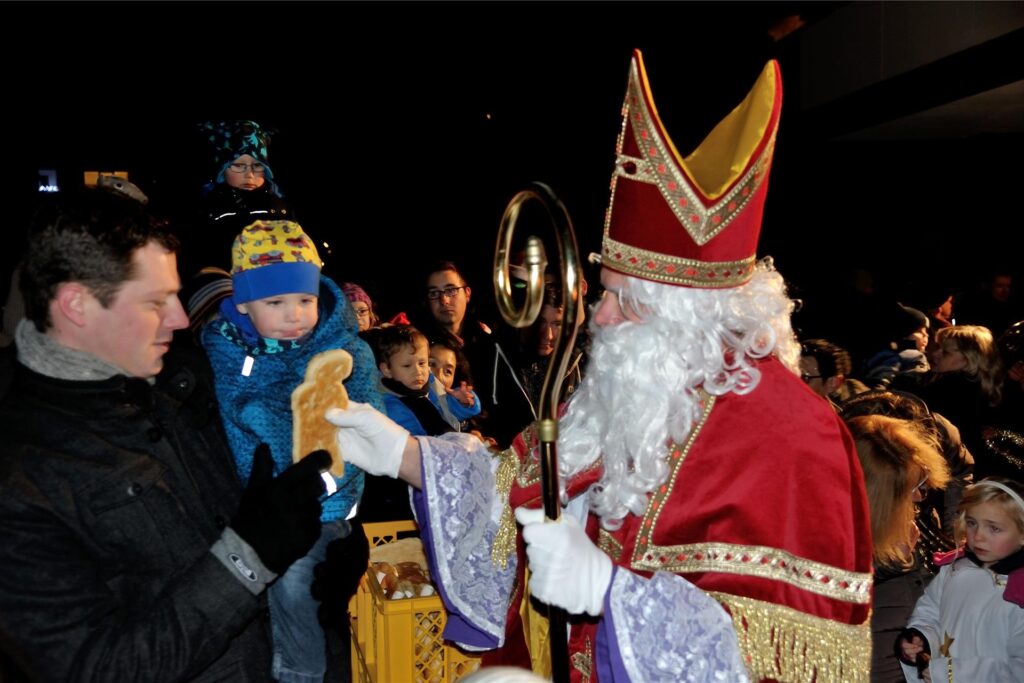 Der Nikolaus gibt einem kleinen Jungen einen Stutenkerl. Der Nikolaus gibt einem kleinen Jungen einen Stutenkerl.