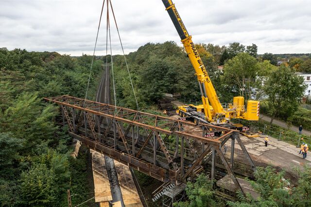 Ein hoher Kran hält eine Brücke.