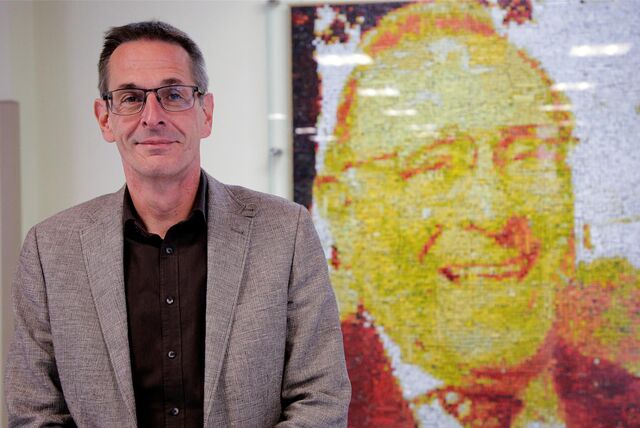 Realschulleiter Frank Cremer vor dem überlebensgroßen Portrait von Alexander Lebenstein, dem Namensgeber der Schule.