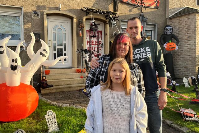 Melanie und Michael Richter und ihre Tochter Lea stehen von ihrem Gruselhaus in Ickern.