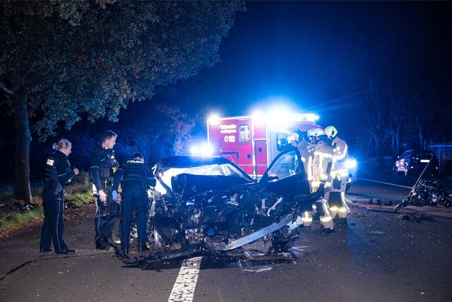 Ein völlig demolierter Mercedes steht bei Nacht auf der Marler Straße in Recklinghausen. Einsatzkräfte von Polizei und Feuerwehr stehen um das Fahrzeug herum.