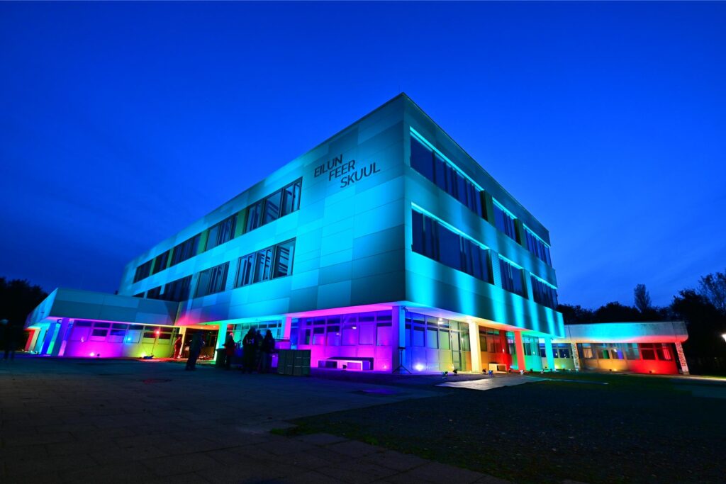 Das Gymnasium Eilun Feer Skuul erstrahlt in buntem Licht.