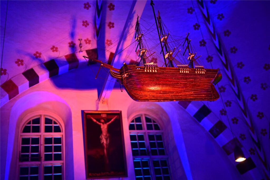 Ein Schiff und ein Bild von Jesus werden angestrahlt.