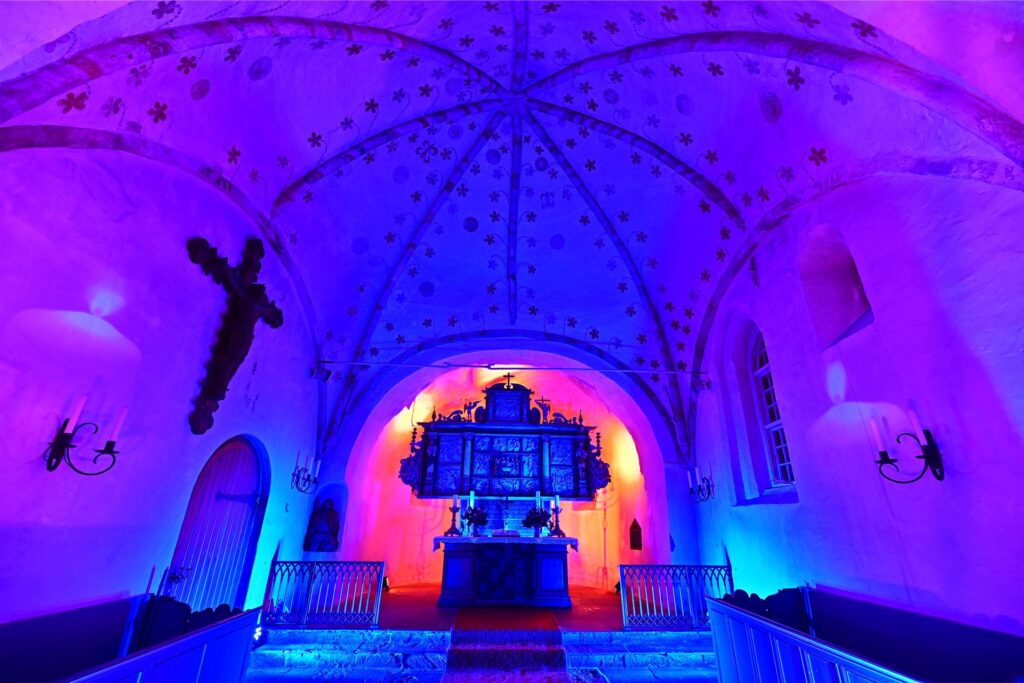 Der Innenraum der St.-Nicolai-Kirche in blauem und magenta Licht.