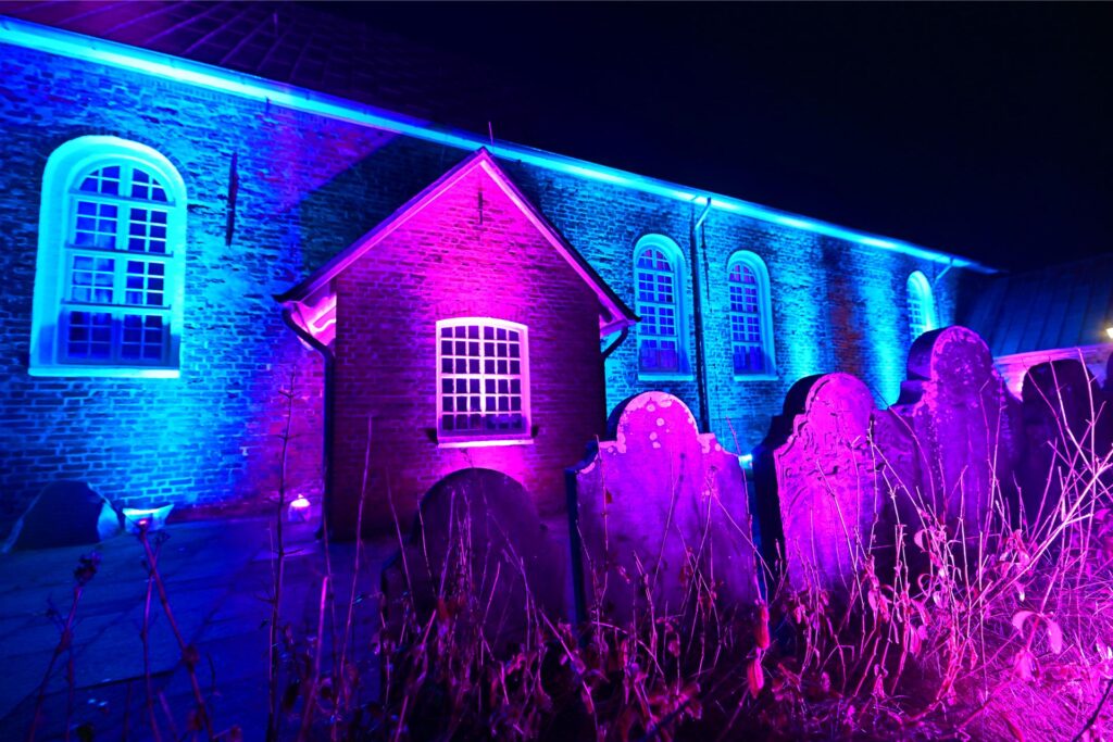 Die St.-Nicolai-Kirche in blauem und magenta Licht.