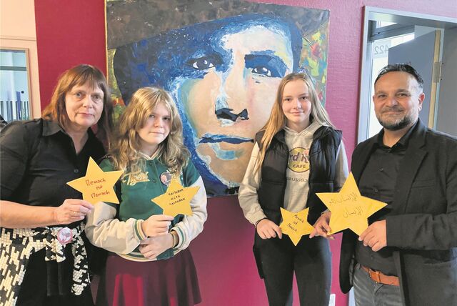 Lehrerin Ursula Nauen, Elisabeth Eirich und Angelina Pink (beide aus der 9c) stehen gemeinsam mit Künstler Adnan Kassim (v.l.) vor einem Bild.