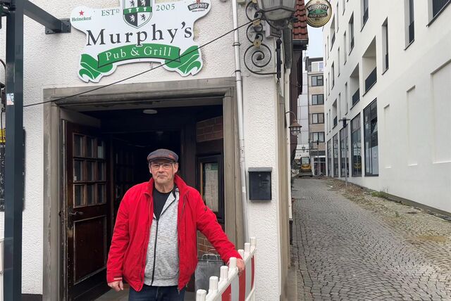 Ralf Teubner steht hinter dem Bauzaun vor seinem Irish Pub im Lampengässchen.
