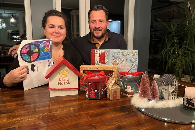 Jessica und André Bänsch an ihrem Wohnzimmertisch mit einem Wunschzettel in der Hand. Vor ihnen stehen selbstgemachte Sachen, die sie auf ihrem Tannenbaummarkt verkaufen.