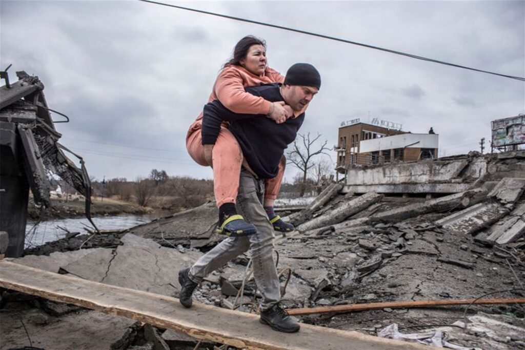 Größtmögliches Leid der Zivilbevölkerung: Ein Mann trägt eine Frau durch Trümmer. Sie sind auf der Flucht aus der ukrainischen Stadt Irpin. Größtmögliches Leid der Zivilbevölkerung: Ein Mann trägt eine Frau durch Trümmer. Sie sind auf der Flucht aus der ukrainischen Stadt Irpin.