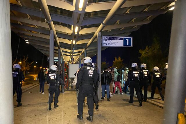 Polizisten laufen in einer Reihe auf dem Busbahnhof, um Jugendliche von der Platte zu drängen.