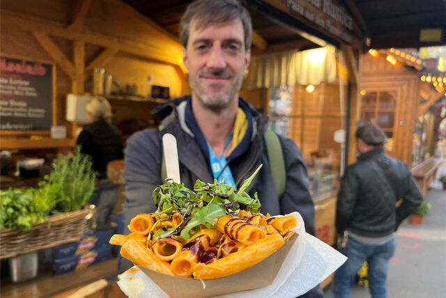 Reporter Tim Schulze mit Pasta aus dem Parmesanlaib auf Dortmunds Hansemarkt.