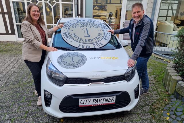 Eine Frau und ein Mann stehen an einem Auto