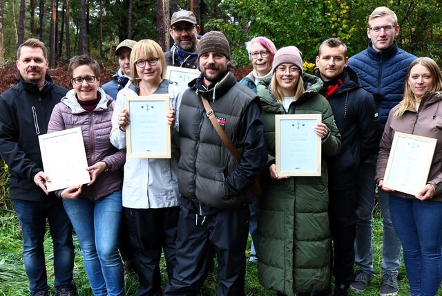 Eine Gruppe Menschen mit Urkunden in der Hand nach einer Hochzeitsbaum-Pflanzaktion in Haltern.