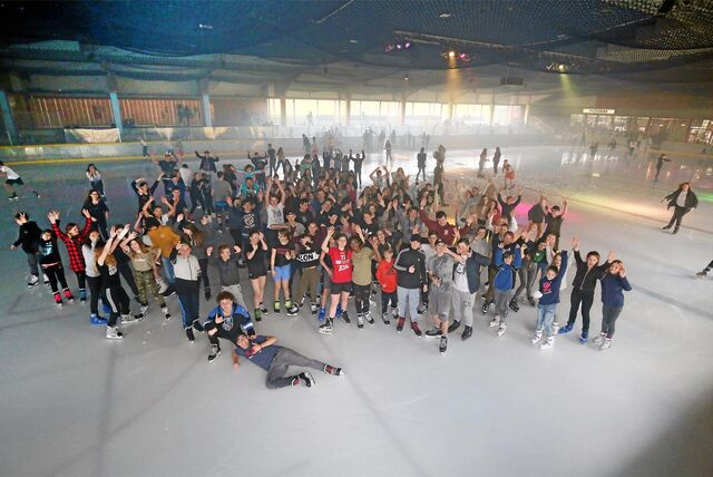 Eine große Gruppe junger Menschen steht auf der Eisfläche der Eissporthalle in Bergkamen.