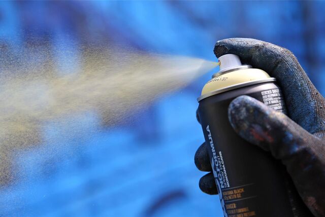 Ein Finger drückt auf den Knopf einer Spraydose.