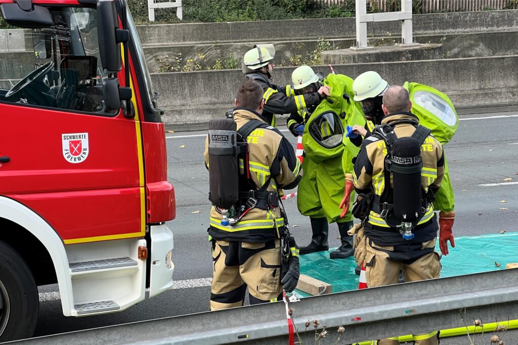 Feuerwehrleute stehen an der Unfallstelle auf der A1. Feuerwehrleute stehen an der Unfallstelle auf der A1.
