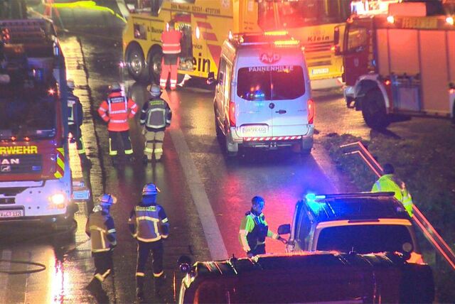 Autos fahren auf dem Standstreifen der A1 an einem umgekippten Chemielaster vorbei.