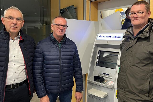 Drei Volksbank-Mitarbeiter stehen an einem Geldautomaten in der Sythener Filiale.