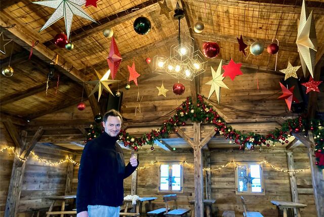 Max Schmitz hebt den Daumen in der weihnachtlich dekorierten Almhütte in Waltrop.