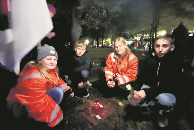 Vier Jugendliche legen Rosen an jüdischen Gräbern nieder.