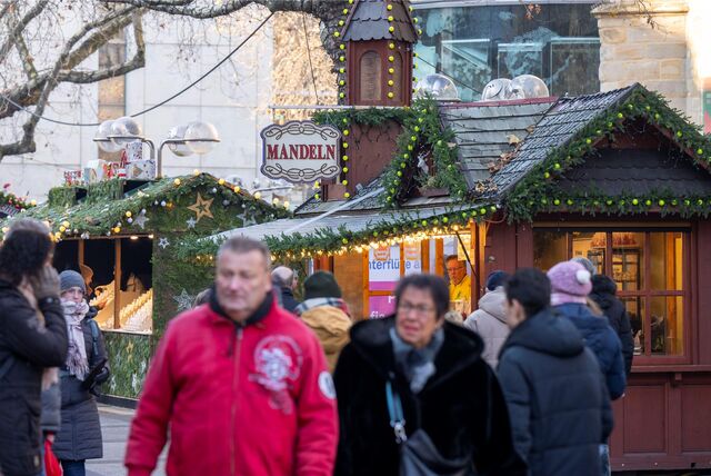 Passanten gehen über den Weihnachtsmarkt in Dortmund