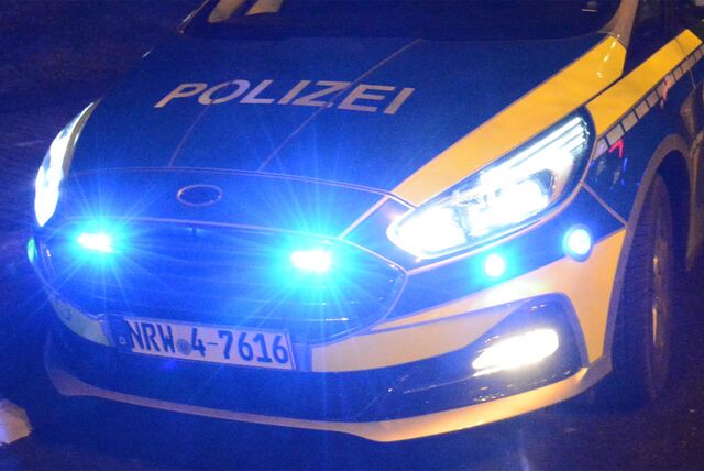 Polizei-Einsatzwagen mit Blaulicht in der Dunkelheit.
