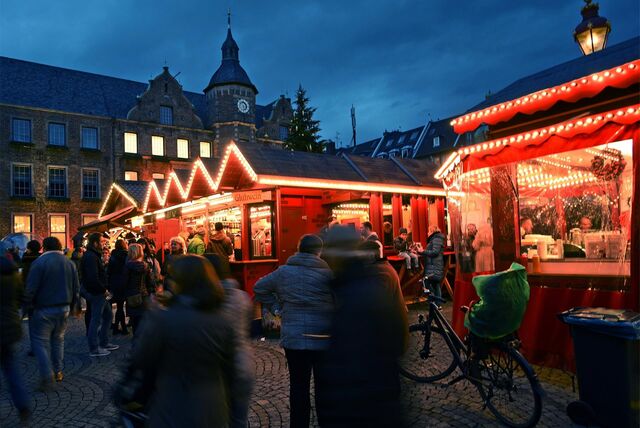 Das Rathaus ragt auf dem Weihnachtsmarkt in Düsseldorf hinter den Verkaufsständen hervor.