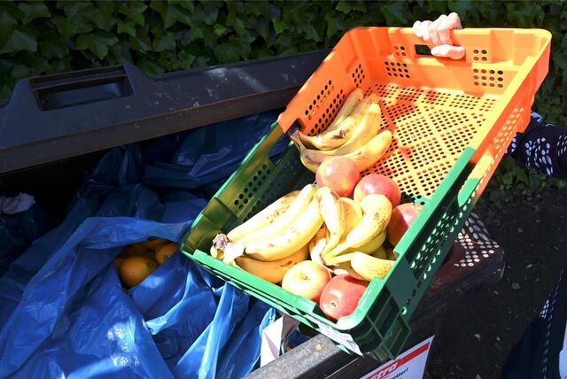Ein Mitarbeiter des Supermarktes Lestra bringt Obst zu einem Müllcontainer.