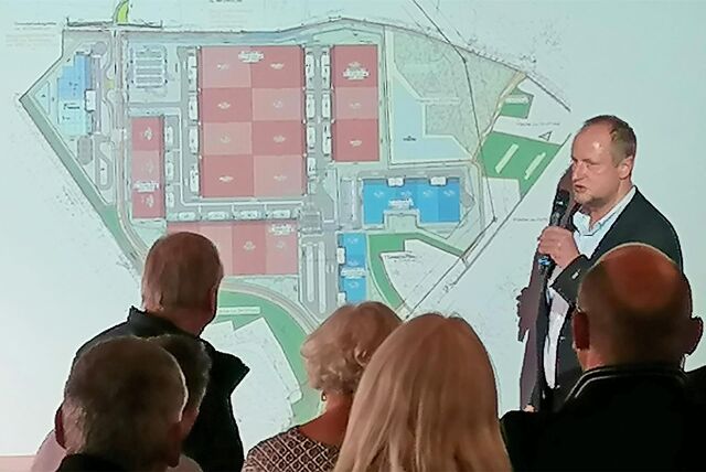 Segro Manager Carsten Lümkemann und Anwohner vor einer Leinwand mit dem Plan für den Gewerbe- und Logistikpark.