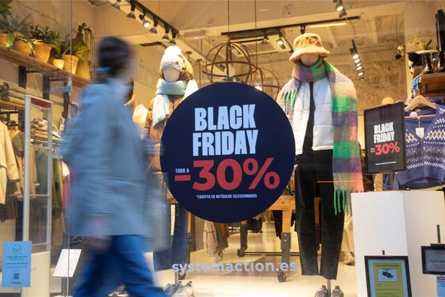 Das Schaufenster eines Textilgeschäfts präsentiert ein Black Friday Plakat.
