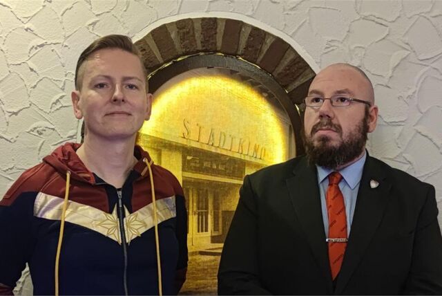 Eine Frau und ein Mann stehen in einem Lokal.