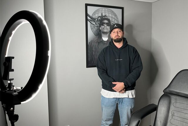 Ein Mann steht in einem Tattoo-Studio.