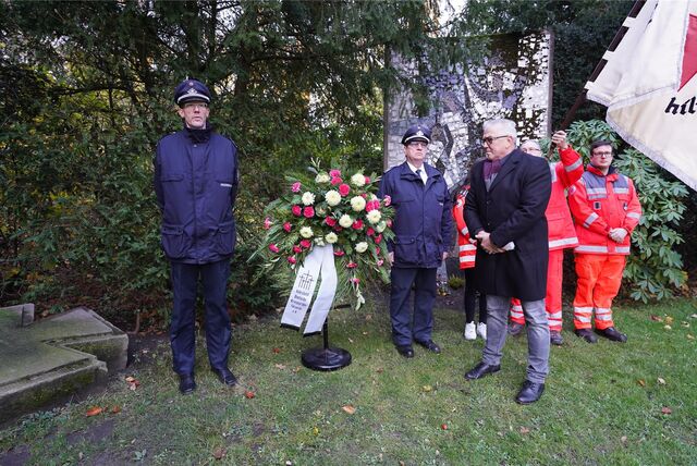 Menschen vor Blumenkranz