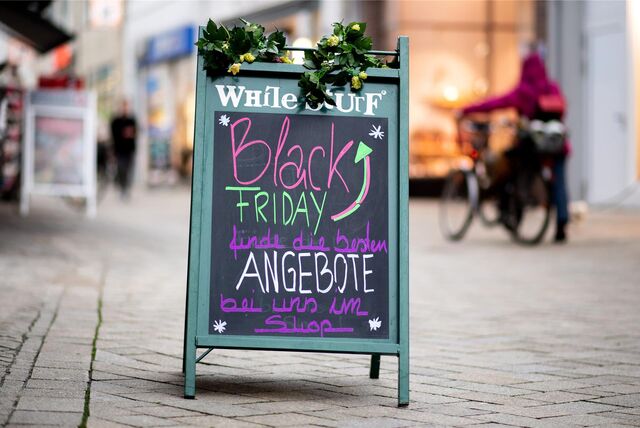 Ein Werbeaufsteller steht in einer Fußgängerzone und wirbt mit Black Friday Angeboten.