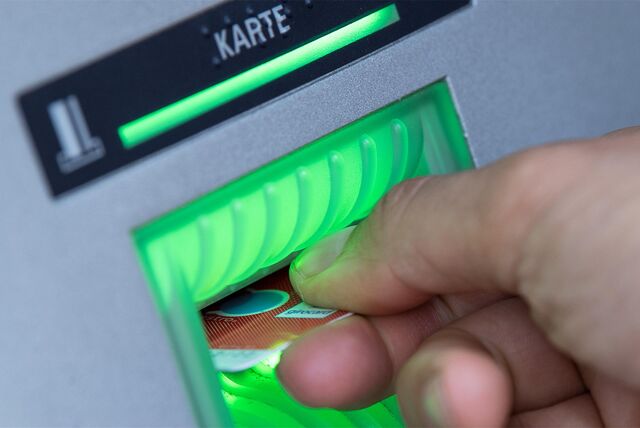 Das Symbolbild zeigt eine Hand mit EC-Karte am Bankautomaten.