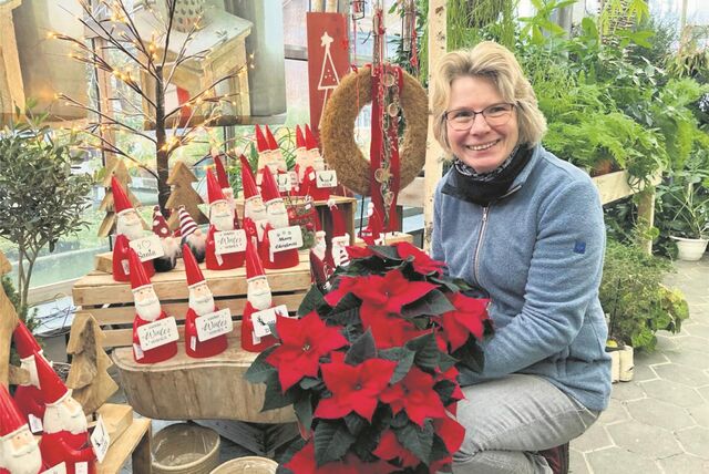 Susanne Luthe mit Weihnachtssternen und Wichteln.