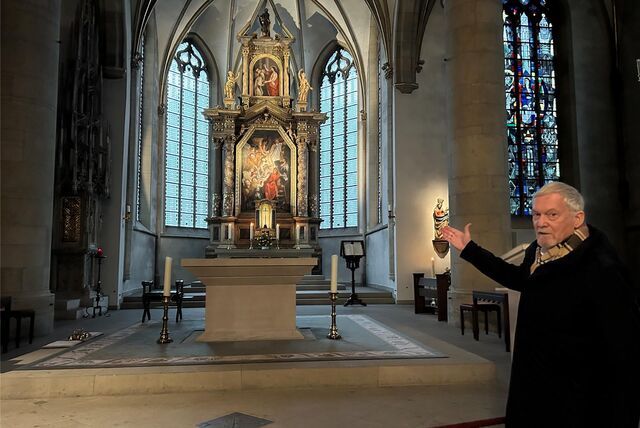 Dr. Werner Koppe zeigt auf den Hochaltar in der Propsteikirche St. Peter in Recklinghausen.