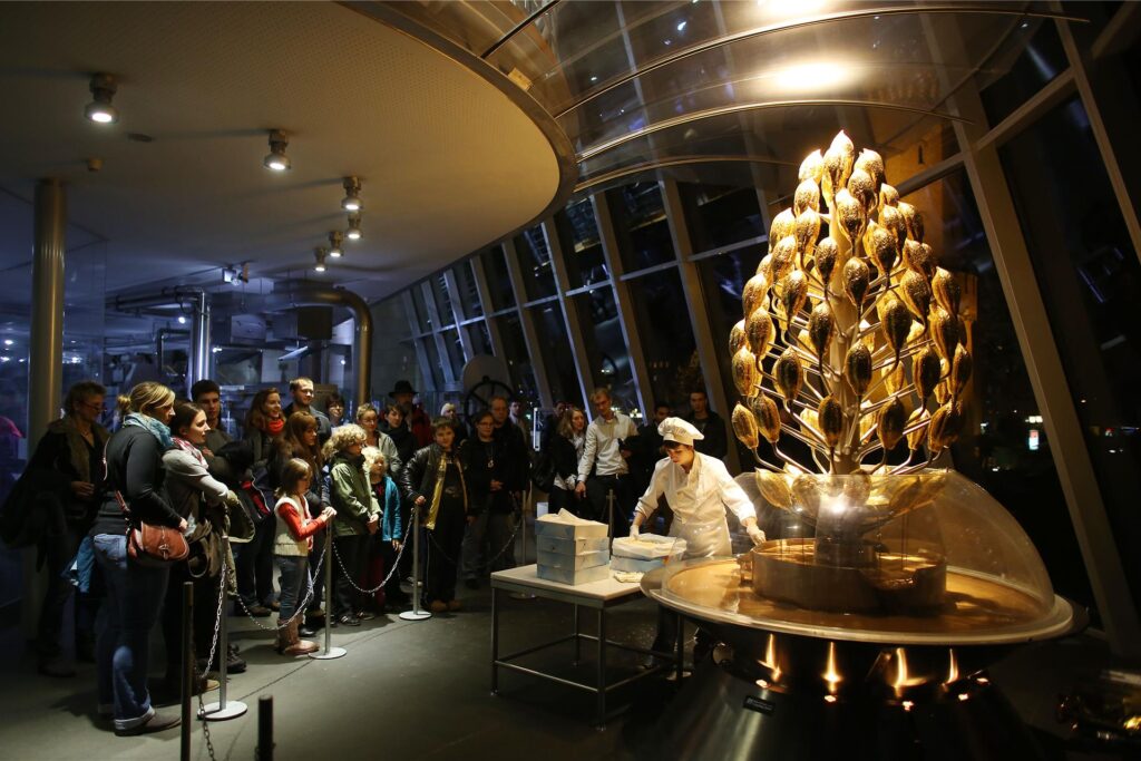 Besucher im Schokoladenmuseum Köln stehen vor dem Schokobrunnen.